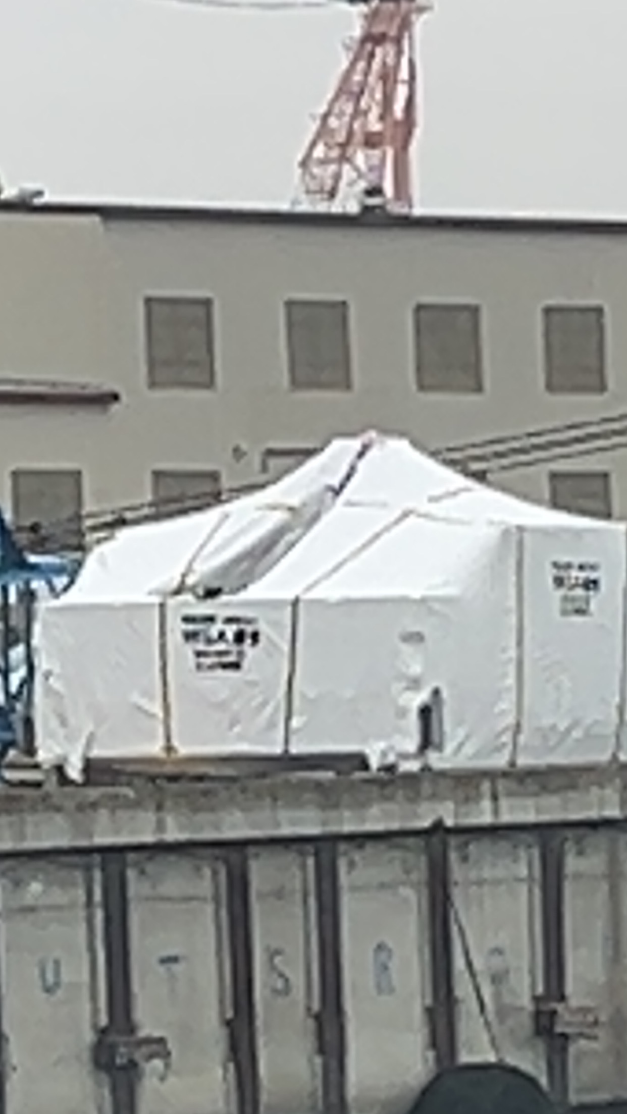 Large modular structures covered in protective shrink wrap